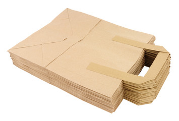 Group of flat unfolded plain brown paper take away food carrier bags with handles isolated on a white background