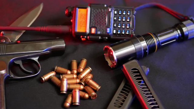Makarov pistol, bullets, radio and flashlight on the black backround