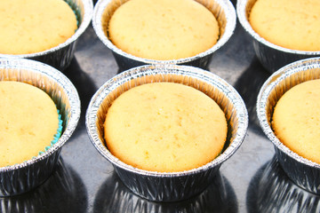 Ready baked muffins on a wooden table.