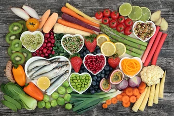 Foto op Plexiglas Gezond superfood concept met verse vis, groenten en fruit in hartvormige schotels en los. Gezondheidsvoedsel rijk aan omega 3, antioxidanten, anthocyanen, mineralen, vitaminen, bovenaanzicht. © marilyn barbone