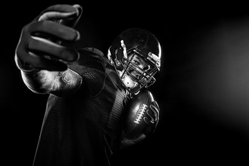 Sport concept. American football sportsman player on black background. Sport concept.