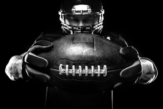Sport concept. American football sportsman player on black background. Sport concept.