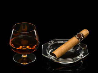 Cognac and cigar in a glass ashtray