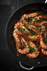 Shrimps fried in a pan. Classic recipe - parsley, garlic, chilli peppers and white wine.