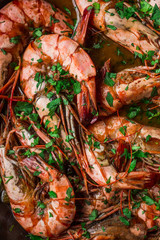 Shrimps fried in a pan. Classic recipe - parsley, garlic, chilli peppers and white wine.
