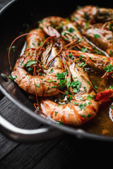 Shrimps fried in a pan. Classic recipe - parsley, garlic, chilli peppers and white wine.