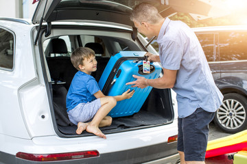 Father and son are packing car for vacation
