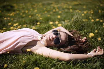 A beautiful woman in her dress enjoys a glade of mountain flowers