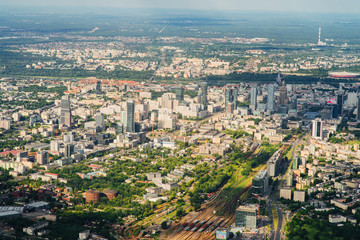 Aerial picture of city with houses and gardens, crossroads and roads, houses, buildings, parks and parking lots, bridges. Airplane drone shot.