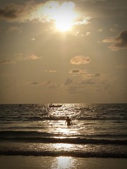 The men in the sea at sunset, splashing gold, Beautiful seaside at Sunset 