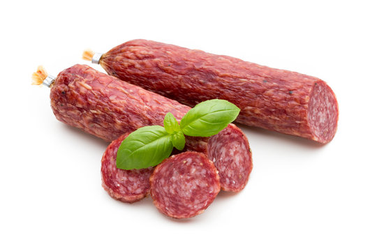 Salami smoked sausage, basil leaves and peppercorns isolated on white background.