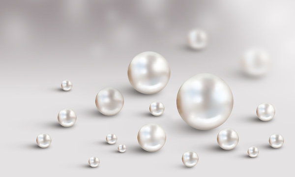 Many small and big white pearls on white and grey bokeh background