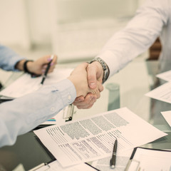 handshake business partners after discussing the terms of a new contract in the workplace in the office