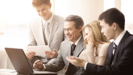 Fototapeta premium serious business team with tablet computers, documents having discussion in office