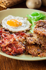 Hash browns. Potato pancakes with crispy fried bacon and fried egg