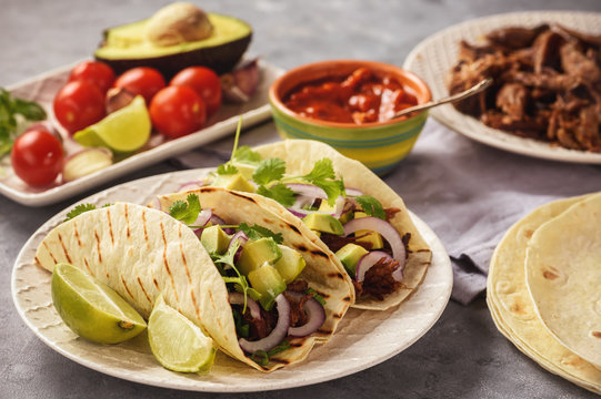 Pulled porc carnitas with avocado and red onion on tortillas. mexican food.