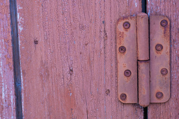 Red old weathered worn rustic wooden boards with rusty metal door hinge. Background