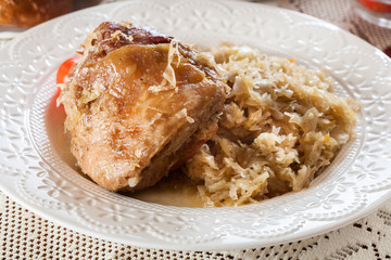 Pork knuckle with fried sauerkraut and tomatoes