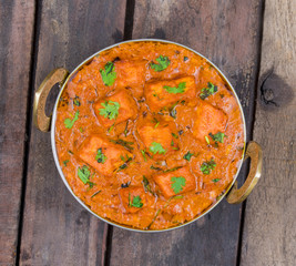 Indian Delicious Cuisine Paneer Tikka Masala Also Called Paneer Butter Masala is an Indian Dish of Marinated Paneer Cheese Served in a Spiced Gravy on Wooden Background