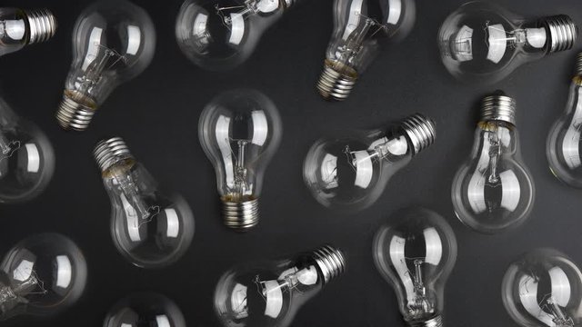 Chain reaction idea concept. Flashing light bulbs on black desk