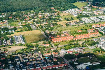 Aerial picture of city with houses and gardens, crossroads and roads, houses, buildings, parks and parking lots, bridges. Airplane drone shot.
