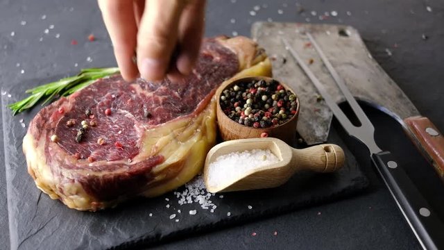 Marbling ribeye steak on black plate. Prime rib beef chop