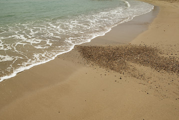 Shore of the beach where you can see foam on the sand. Summer.