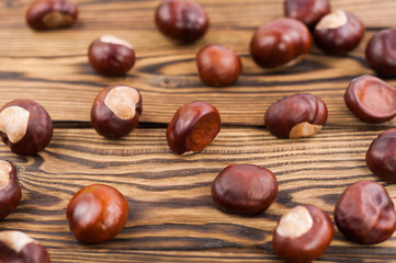 Scattered brown chestnuts on old wooden rustic brown table