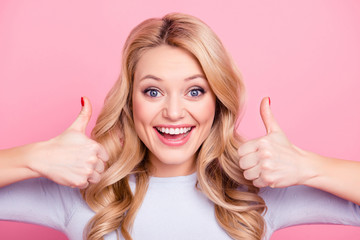 Close up portrait of pretty good girl with modern hairstyle gesturing two thumbs up like symbols...