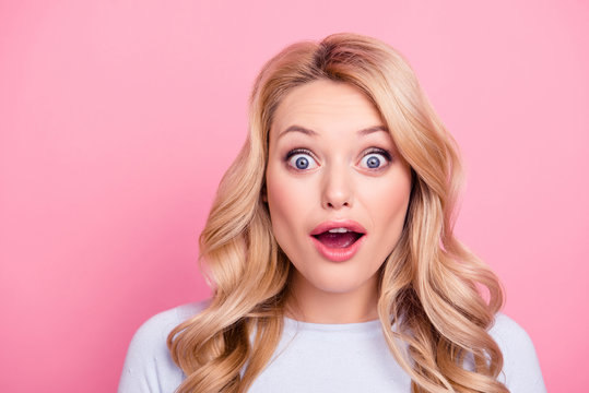 Sale! Portrait of shocked wondered girl with modern hairdo and wide open mouth eyes looking at camera isolated on pink background