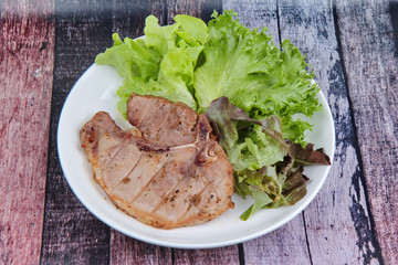 Pork Chop Steak served with mixed vegetable as red oak , green oak and lettuce