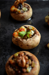 Mushrooms stuffed with cheese on a black background