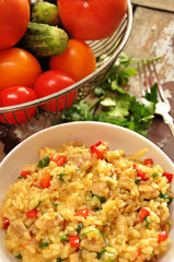 Risotto with chicken in a white bowl on a wooden background