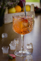 Cocktail with vodka, strawberries and lemon in glass on the bar