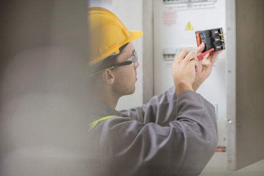 Electrician working at fuse box