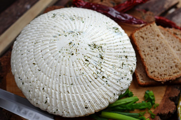 Homemade round white cheese and bread on wood