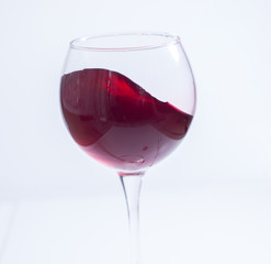 A glass with red wine on a white background. Isolate