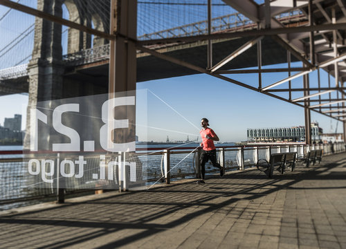 USA, New York City, Man Running At East River With Data Emerging From Smartwatch