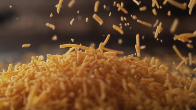 Camera follows shredded cheddar cheese. Shot with high speed camera, phantom flex 4K. Slow Motion.