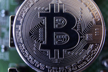 Fototapeta na wymiar Silver souvenir coin Bitcoin on computer circuit board background.