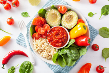 vegan buddha bowl. healthy lunch bowl with avocado, tomato, bell peppers, quinoa and salsa