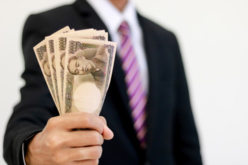 Businessman with money in hand, yen ,investment, success and profitable business concepts.