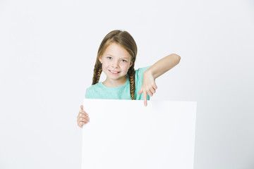 pretty, brunette girl is pointing at white board in front of white background