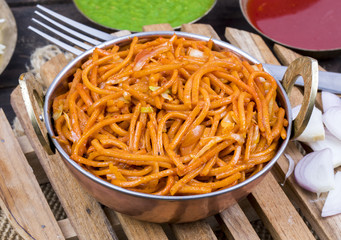 Spicy Fried Vegetable Veg Chow Mein Served With Green And Red Chutney Also Know as Noodles or Hakka Noodles is a Popular Oriental Dish With Noodles And Vegetables on Wooden Table