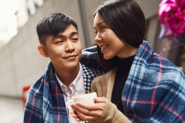 Young asian couple sitting in cafe.