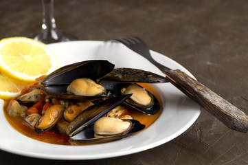 mussels in tomato sauce on a white plate