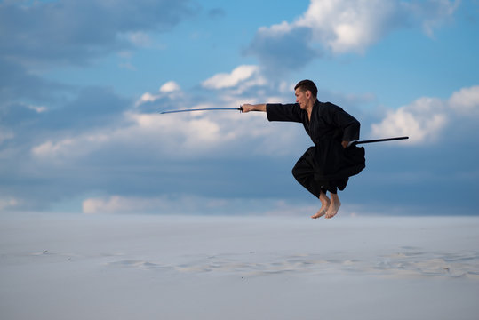 Man jumps during training martial arts in desert