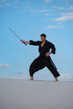 Man is training martial arts in desert