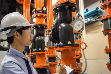 Engineer checking Condenser Water pump and pressure gauge , chiller water pump with pressure gauge.