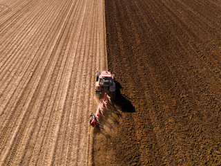 Aerial shot of a farmer plowing stubble field © oticki